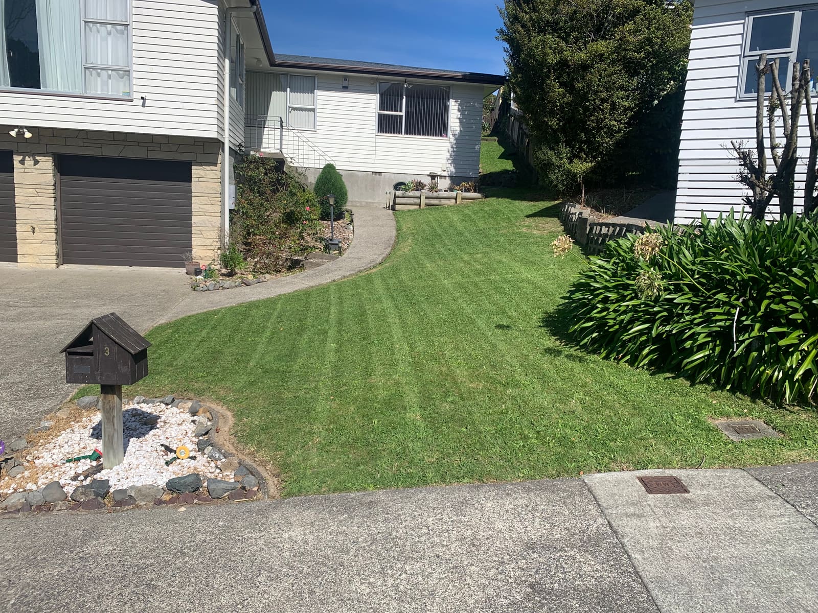 Freshly mowed front lawn with neat stripes outside a Porirua home